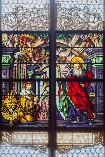 Accompanied by the coat of arms of the Holy Roman Empire displaying the crowned double-headed eagle, Emperor Charles V († 1558) is depicted kneeling on the left in front of the Apostle James, the patron saint of Spain.