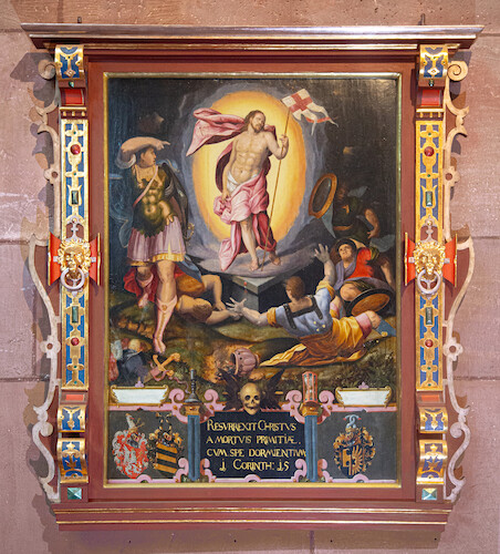 The lower memorial plaque was donated by Barbara von Lichtenfels for her two husbands Wilhelm Stürzel († 1559) and Christoph von Bernhausen († 1563). The resurrected Christ in a gloriole triumphs over death. The familys' coats of arms are shown next to the inscription, which is crowned by a skull.