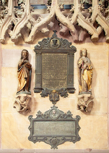 The epitaphs on the wall of the high choir also belongs to the university chapel. The upper, larger epitaph commemorates the poet and humanist Heinrich Glarean († 1563), who died in Freiburg. The smaller memorial plaque commemorates the professor of Greek and Hebrew, Johannes Hartung († 1579).