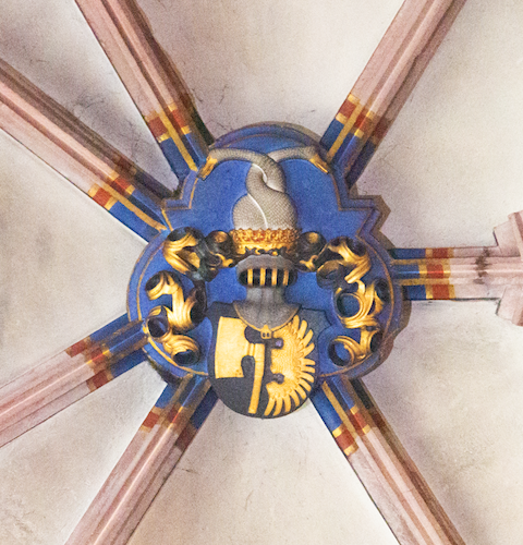 The vault keystone in the chapel shows the coat of arms of the von Lichtenfels family. A golden axe and a golden wing on a black shield are crowned by a helmet above which is a golden crown with two swan necks entwined.
