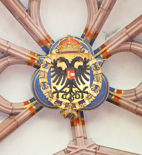 The imperial coat of arms with the crowned double-headed eagle can be seen in the magnificent curved and broken ribs vaulting inside both imperial chapels.