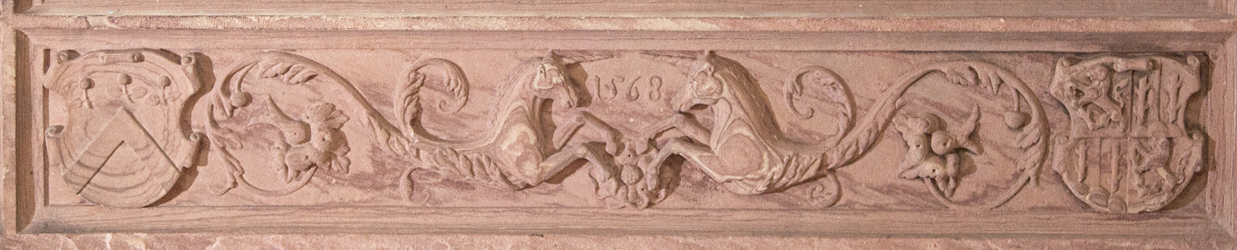 The right-hand plinth feature an impressive depiction of two unicorns, which merge into the ornate tendrils. In the Middle Ages, the unicorn was a symbol that was also associated with Christ due to its unique status among animals. Between the heads of the two mythical creatures, the date of origin of the plinth stones is carved in relief. The coat of arms with the three cherries refers to Apollinar Kirser and his wife from the Welsinger family.