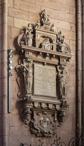 Appolinar Kirser, the donor of an earlier altar from the 16th century, is represented by an epitaph in the chapel. The wall epitaph, made of grey sandstone and marble, contains a large inscription panel framed by angels and magnificent Renaissance architecture. The suffering Mary with her deceased son, depicted in a medallion and known as the Pieta, is a popular depiction that symbolises death in a Christian context. The epitaph is rounded off with a large, decorative coat of arms from Kirser.