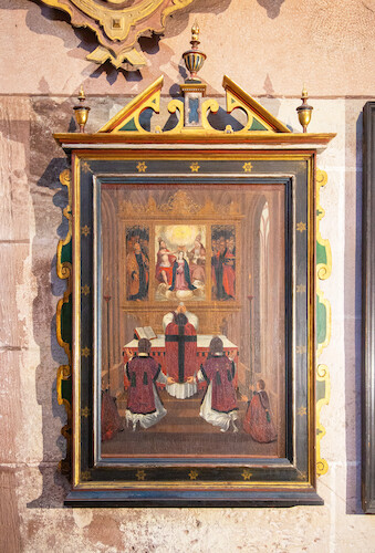 The first painting shows five clergymen: But this is not just a popular prayer scene, it depicts the Freiburg Minster - The painted altar shows a depiction of the Freiburg high altar by Hans Baldung Grien with the Coronation of the Virgin, flanked by the apostles Peter and Paul on the side panels.